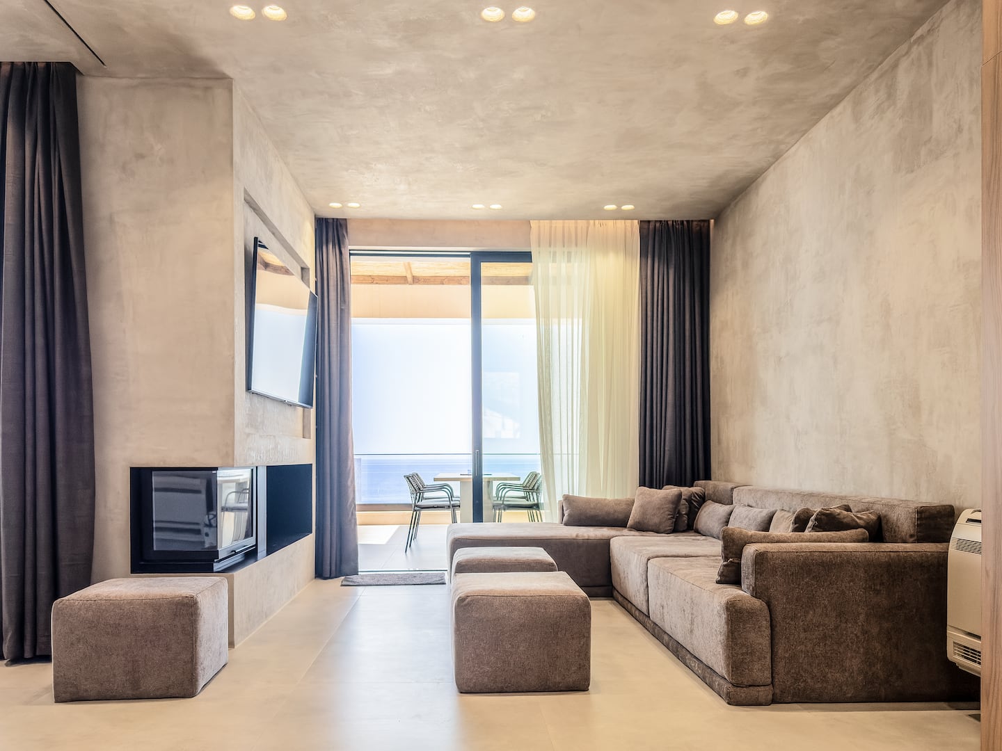 Living room at Villa 4 with a built-in fireplace and view to the cove.