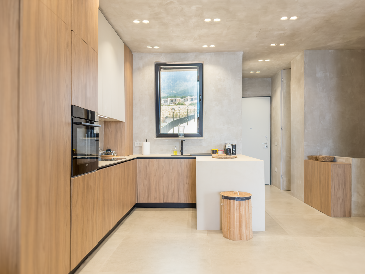 Full kitchen at Villa 4 — oak cabinetry, integrated appliances, tiled floor.