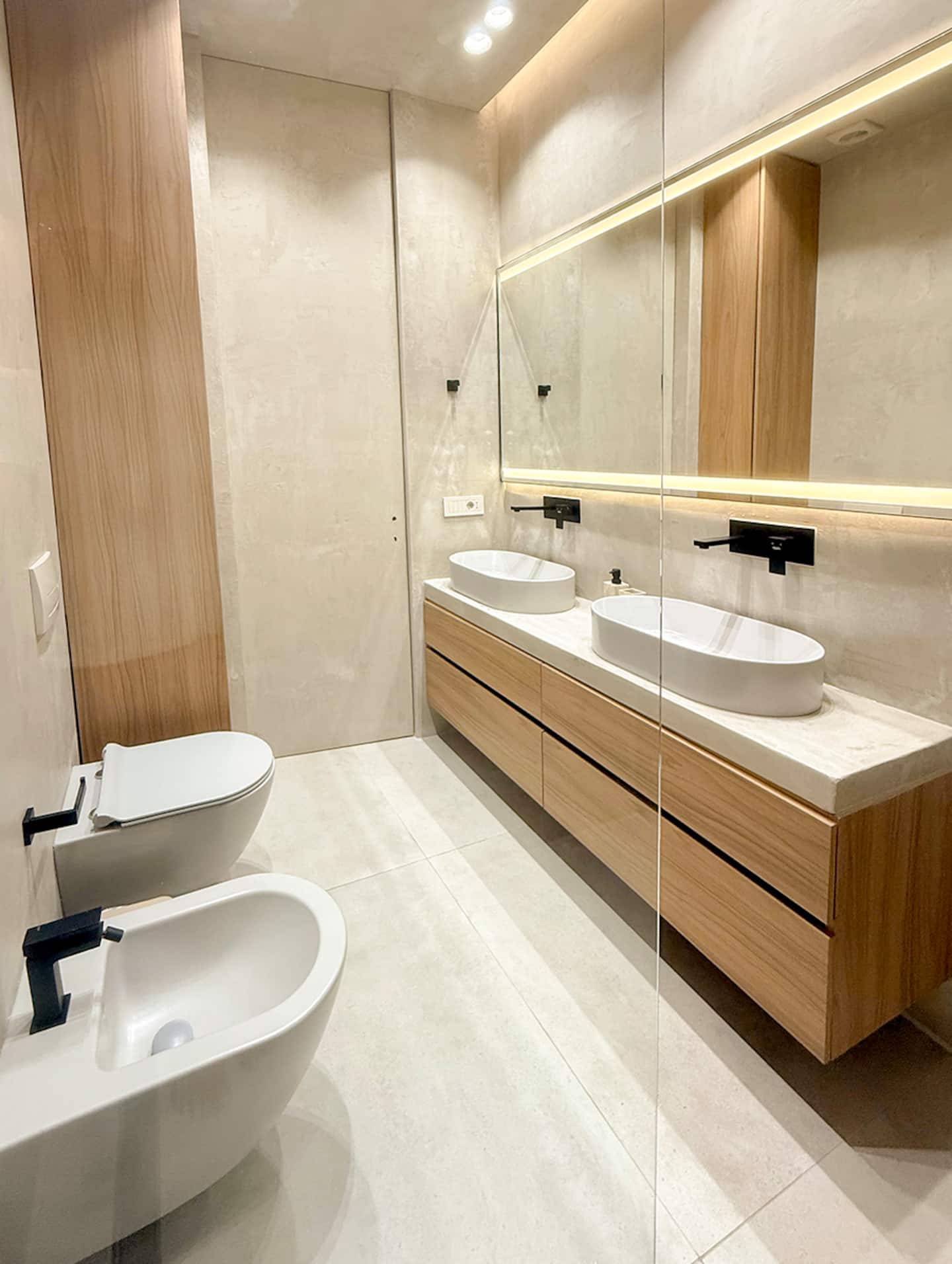 Bathroom at Villa 4 with microcement walls, twin basins, and matte-black fixtures.